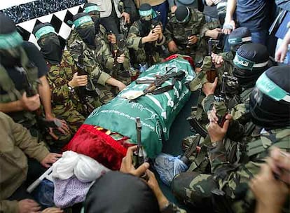 Milicianos de Hamás rodean el cadáver del juez Bassam al Fara durante su funeral, ayer en Jan Yunis.