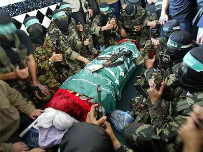 Milicianos de Hamás rodean el cadáver del juez Bassam al Fara durante su funeral, ayer en Jan Yunis.