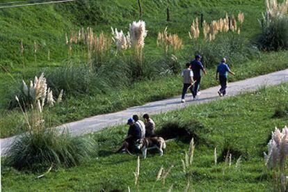 Paseantes en las cercanías de la ría de Solía, el último tramo de la vía verde del Pas, justo antes de encontrarse con el mar Cantábrico.