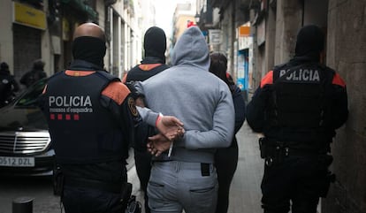 Los Mossos d'Esquadra detienen a un sospechoso durante una macroperación contra narcopisos en Barcelona.
