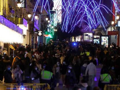 El virus no basta para cambiar algunos hábitos. Personas se congregan para hacer compras y disfrutar de las luces navideñas en la calle de Preciados, en Madrid. 