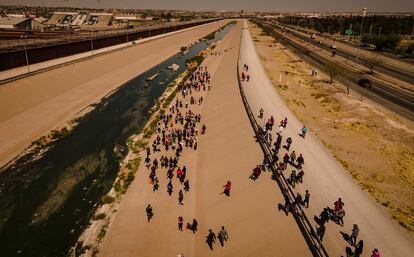 Vista aérea de decenas de migrantes caminando hacia el cruce fronterizo de Ciudad Juárez. 