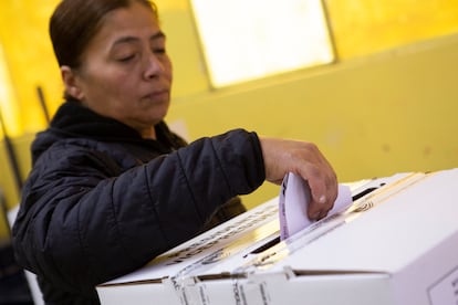 Una mujer deposita su voto en las urnas colocadas en el Instituto Tecnológico Superior Central Técnico, al norte de Quito.