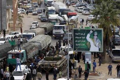 Un convoy de 18 camiones cargados de alimentos cruza un barrio de Trípoli protegido por blindados leales al dictador.