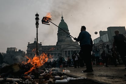 A man burns a box during clashes between police and people protesting outside the Argentine Congress, this Wednesday, June 12. 