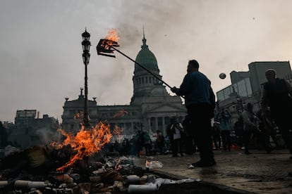 Un hombre quema una caja frente a la sede del Congreso.