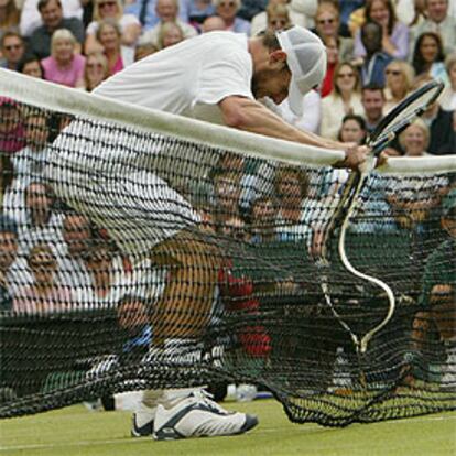 Roddick presiona la red tras perder un tanto con Federer.