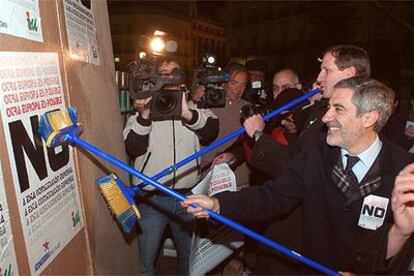 Gaspar Llamazares (derecha) y Willy Meyer pegan carteles por el <i>no</i> a la Constitución europea en la Puerta del Sol de Madrid.