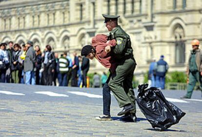 Un policía detiene a un ecologista en Moscú durante una protesta en la plaza Roja.