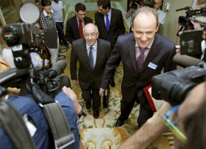 El gobernador del Banco de España, Miguel Ángel Fernández Ordóñez -centro-, a su llegada hoy a la comisión de presupuestos del Congreso.