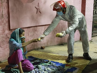 Una mujer sin hogar recibe alimentos de un grupo de voluntarios durante el confinamiento por la covid-19 en Bangladés en 2020.