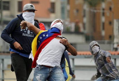 Un manifestante afín al partido opositor lanza una piedra durante las protestas de este miércoles en Caracas.