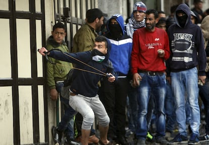 Un palestino usa un tirachinas para lanzar piedras contra las tropas israelíes durante los enfrentamientos en la ciudad de Hebrón.