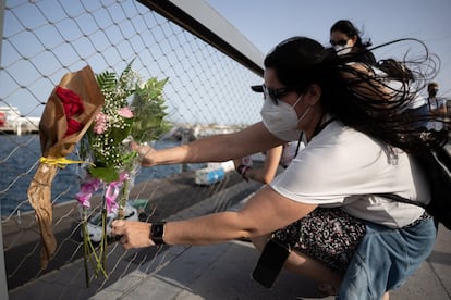 Una mujer coloca un ramo de flores en el puerto de Santa Cruz de Tenerife durante una concentración de repulsa por la muerte de Olivia, de 6 años, y en solidaridad con la familia de esta niña y de su hermana Anna.