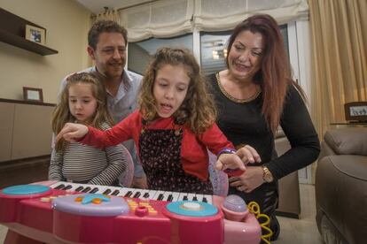 Sheyna, que padece una enfermedad rara, juega con sus padres y su hermana pequeña en su casa de Castelldefels (Barcelona)