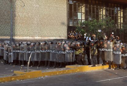 Un grupo de policías forma un muro con sus escudos antidisturbios, en las calles del centro de Lima el jueves.