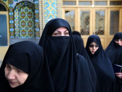 Varias mujeres aguardan para votar en un colegio electoral de la ciudad e Qom.