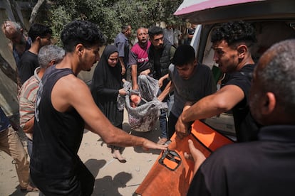 Unos palestinos transportan el cuerpo de una de las víctimas del último ataque israelí sobre Deir al Balah, en el centro de Gaza, este martes.