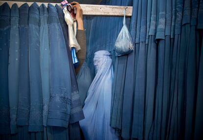 Una afgana espera en el probador de una tienda para probarse un burka en Kabul, Afganistán, el 11 de abril de 2013.