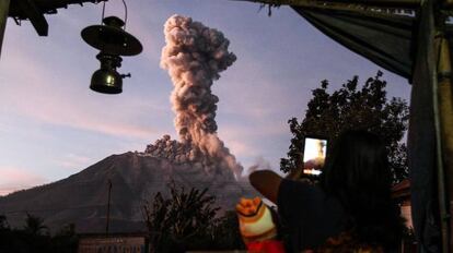 Un aldeano indonesio toma una foto del volcán Mount Sinabung mientras arroja un denso humo. La imagen está tomada desde la aldea de Tiga Pancur en Karo, Sumatra del Norte.