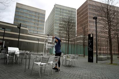 Una camarera prepara la terraza del restaurante donde trabaja para atender a sus clientes, en L'Hospitalet de Llobregat.