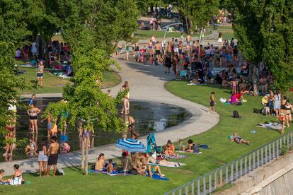 Decenas de personas, a remojo en los chorros de Madrid Río o buscando la sombra, el jueves en la capital.