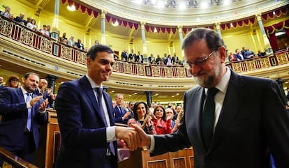 Spain's new Prime Minister Pedro Sanchez shakes hands with Mariano Rajoy.