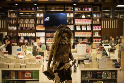 Un hombre caracterizado de tastoan ( celebración religiosa mexicana) recorre los pasillos de la Feria Internacional del Libro recitando poesía indígena.