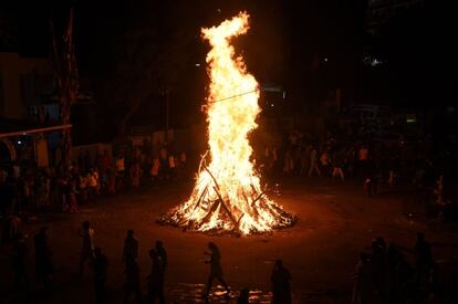 El festival Holi se celebra cada año en una fecha diferente, dependiendo de la última Luna llena del mes lunar hindú Phalguna, el undécimo de su calendario (suele caer entre finales de febrero y mediados de marzo). Son dos días de fiesta que comienzan la víspera (Holika Dahan) con el encendido de una pira al crepúsculo, alrededor de la cual se baila y se tocan tambores, algo que simboliza la quema de la maldad. Una escenificación de la leyenda, contada en las 'Upanishád', los 'Puranas' y otros textos sagrados del hinduismo, de Jirania Kashipú, rey de los demonios, matado por un avatar del dios Visnú, y de su hermana Holika, quemada en una hoguera mientras ambos trataban de acabar con la vida del hijo de Jirania Kashipú. En la imagen, la celebreación del Holika Dahan, anoche en la ciudad de Ahmedabad.