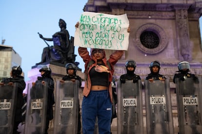 Una mujer frente a policías de la Ciudad de México, en el Ángel de Independencia. 