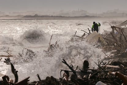 Un voluntario camina este lunes mientras busca víctimas de la destrucción a orillas del Mediterráneo en la playa del Saler (Valencia).