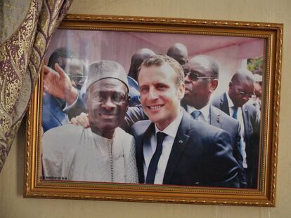 Golbert Diagne junto al presidente francés Emmanuel Macron, en una foto colgada en la pared de su casa.