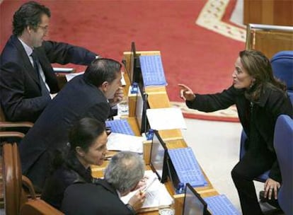 La conselleira de Vivenda, Teresa Táboas, charla con diputados del Grupo Popular durante el pleno del Parlamento de ayer.