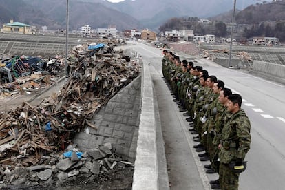 Soldados japoneses rezan por las víctimas del terremoto y el tsunami en la ciudad costera de Otsuchi, prefectura de Iwate, Japón,  un mes después del terremoto y tsunami.