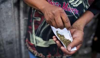 Un hombre limpia marihuana en Tepito.