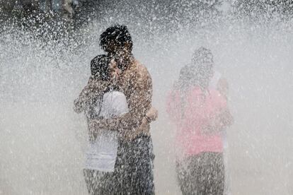 Varios jóvenes tratan de paliar en una fuente las altas temperaturas de este martes en la capital de México.