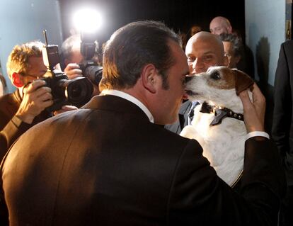 El perro 'Uggie' lame al actor Jean Dujardin al terminar la gala de los Oscar.
