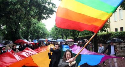 Varios activistas sostienen banderas alusivas a la comunidad LGBT.  