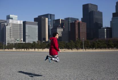 Una turista china salta en la plaza del Palacio Imperial, en Tokio (Japón).