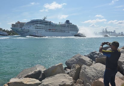 Un hombre fotografía el crucero Adonia, de la compañía Fathom, a su salida este domingo desde el puerto de Miami (EE UU) en dirección a Cuba.