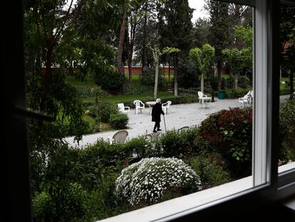 Una anciana pasea por el jardín de una residencia de Madrid.