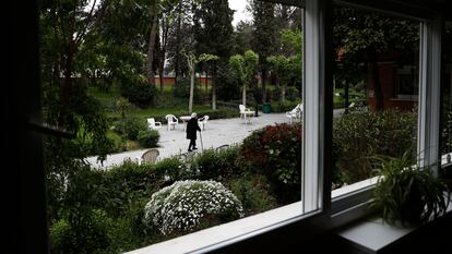 Una anciana pasea por el jardín de una residencia de Madrid.