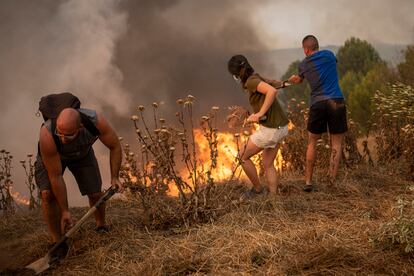 Vecinos colaboran en las labores de extinción en un incendio forestal, en Sant Fruitós del Bages, Barcelona.