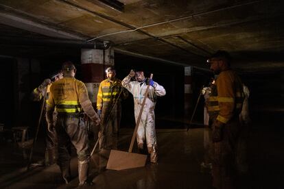 Un equipo de bomberos voluntarios de Castilla y León trabajando en un garaje inundado de Algemesí.