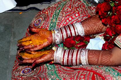 Detalle de las manos de la novia decoradas con complejos patrones de henna durante el ritual del Haldi. En este, uno de los muchos que se celebran durante la ceremonia del tercer día, los novios aplican una pasta amarillenta sobre sus manos. Para esta gran ocasión la novia va ataviada con un sari rojo decorado con pedrería y con numerosas joyas.