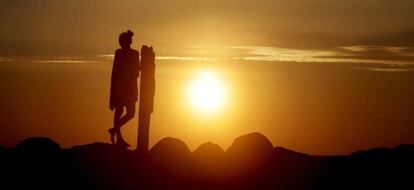 Una mujer disfruta de la llegada del verano con la puesta de sol T