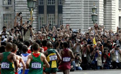 Fotógrafos y público esperan a los corredores, durante el maratón.