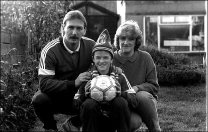 El futbolista David Beckham con sus padres Ted y Sandra, a los 11 años en el jardín de su casa londinense del barrio de Leystone.