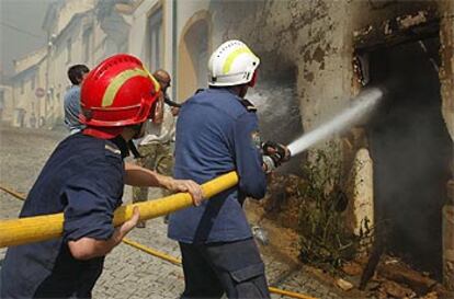Los bomberos tratan de evitar que el fuego se propague en las localidad de Macao, a 100 kilómetros de Lisboa.