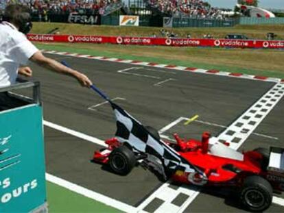 Michael Schumacher levanta el puño en señal de victoria al atravesar la meta del circuito de Magny Cours.